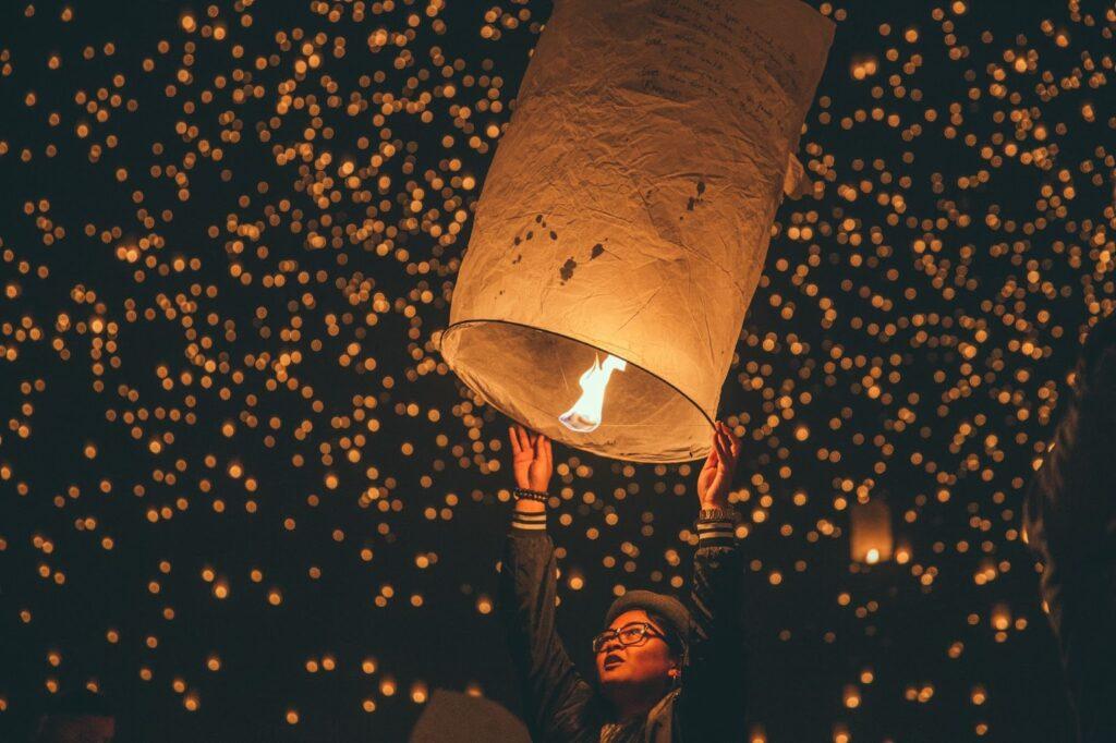Woman releasing lanterns Loy Krathong